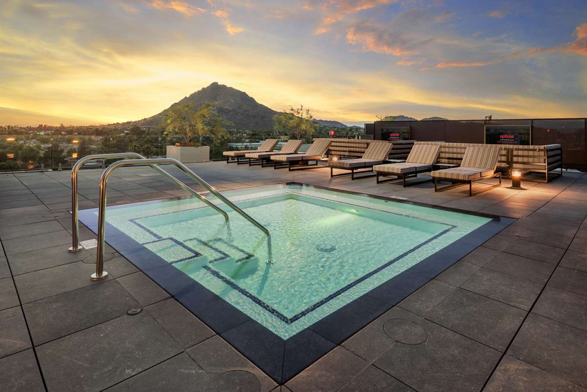 The spa deck at the Optima Sonoran Village residences in Scottsdale, with a scenic sunset backdrop of Camelback Mountain.