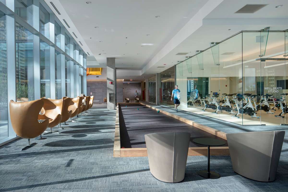 Indoor recreation & resident lounge area with a bocce ball court & glass-enclosed fitness studio at the Optima Signature.