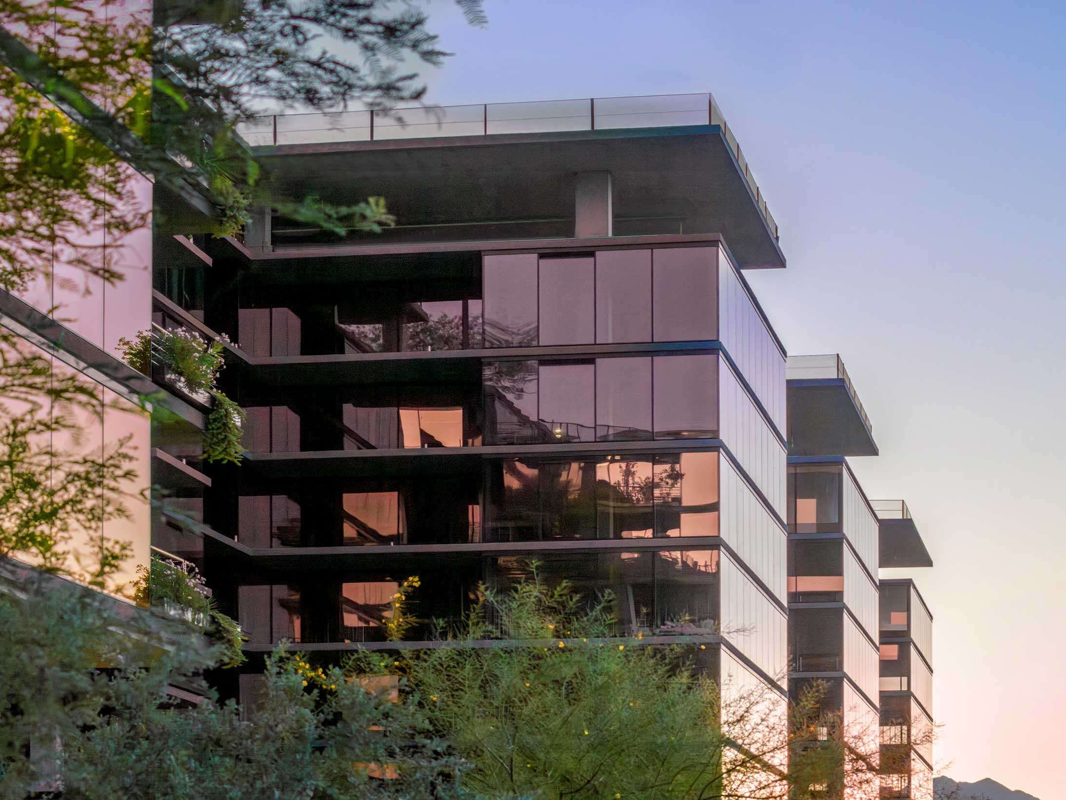 Optima McDowell Mountain, a luxury condo community in North Scottsdale featuring minimalist architecture with glass facades.
