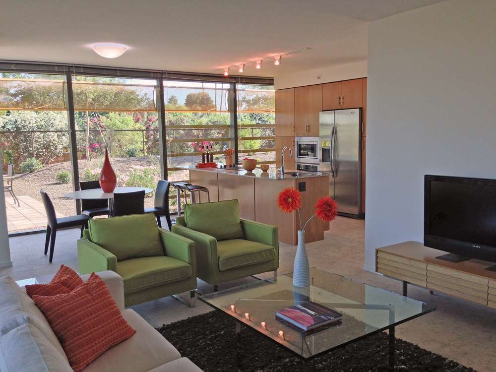 Living room at Optima Sonoran Village luxury apartments in Scottsdale, full length glass walls & modern furniture.