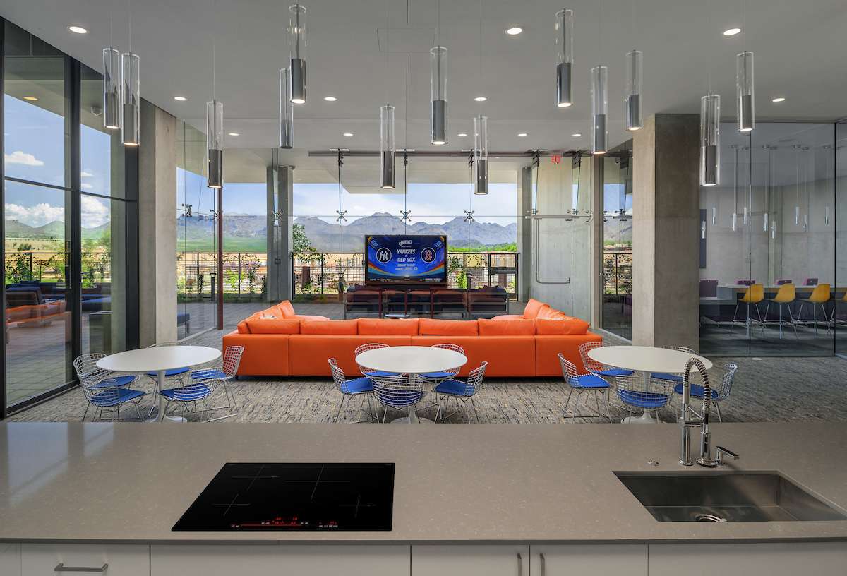 A lounge area at Optima McDowell Mountain luxury apartments in Scottsdale, with floor-to-ceiling windows & modern furniture.