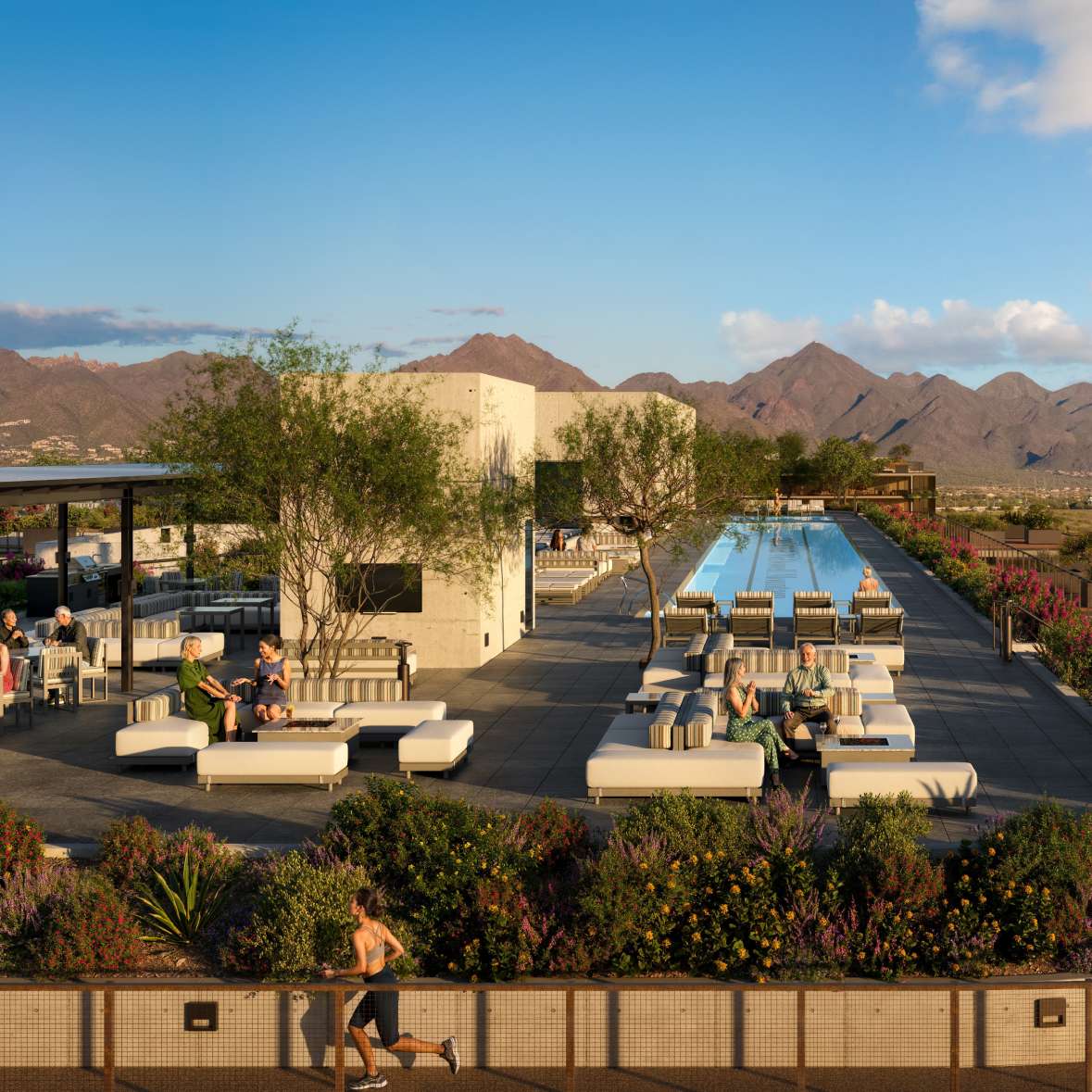 Birdseye view of a rooftop shared space at Optima McDowell Mountain condominium with lap pools and lounge seating with a bbq.